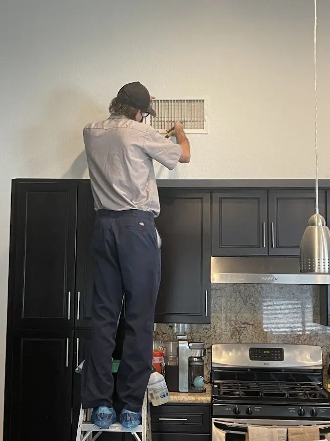Technician inspecting an air vent during HVAC service in Perry Hall